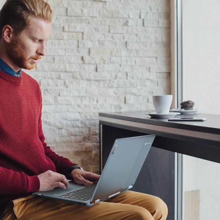 A man sits with Lenovo IdeaPad Chromebook on his lap.