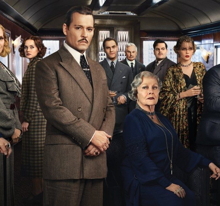 The cast of Murder on the Orient Express poses inside a train.