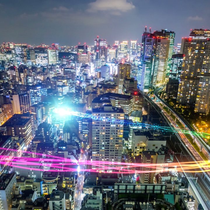 Nighttime cityscape with sweeping color streams.