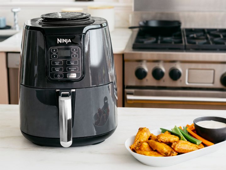 Ninja Air Fryer with wings and sauce.