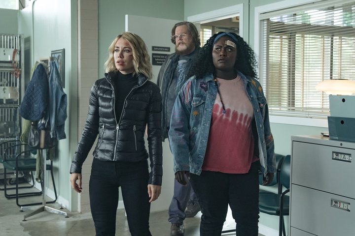 Jennifer Holland, Steve Agee, and Danielle Brooks enter an office in a scene from Peacemaker.