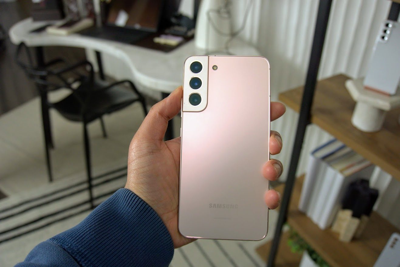 samsung galaxy s22 plus vs apple iphone 13 pro rear in hand pink gold