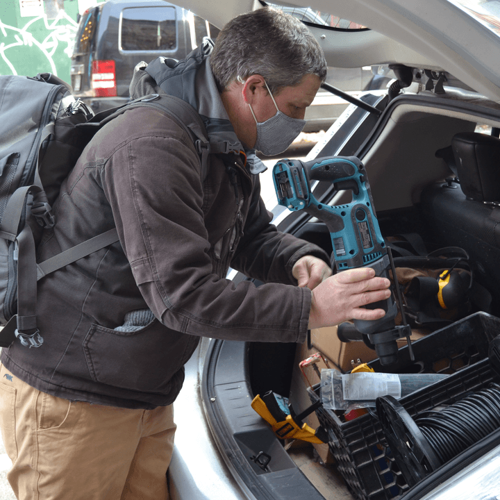 An NYC Mesh volunteer grabs tools from his car.