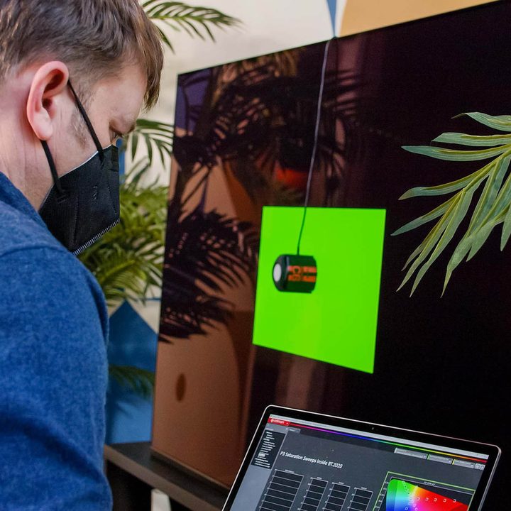 Digital Trends editor Caleb Denison sits in front of the Sony A95K testing the color measurements.