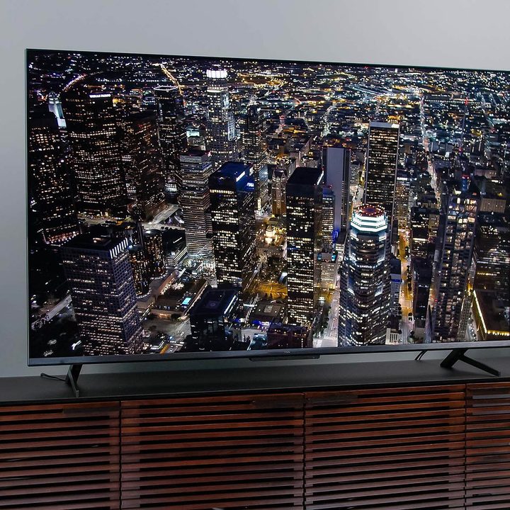 A aerial view of a city at nighttime is shown on the TCL 6-Series Google TV.