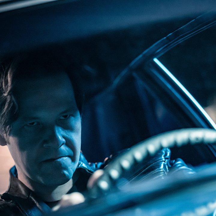 An angry-looking Brett (Ike Barinholtz) drives a car in The Afterparty on Apple TV+.