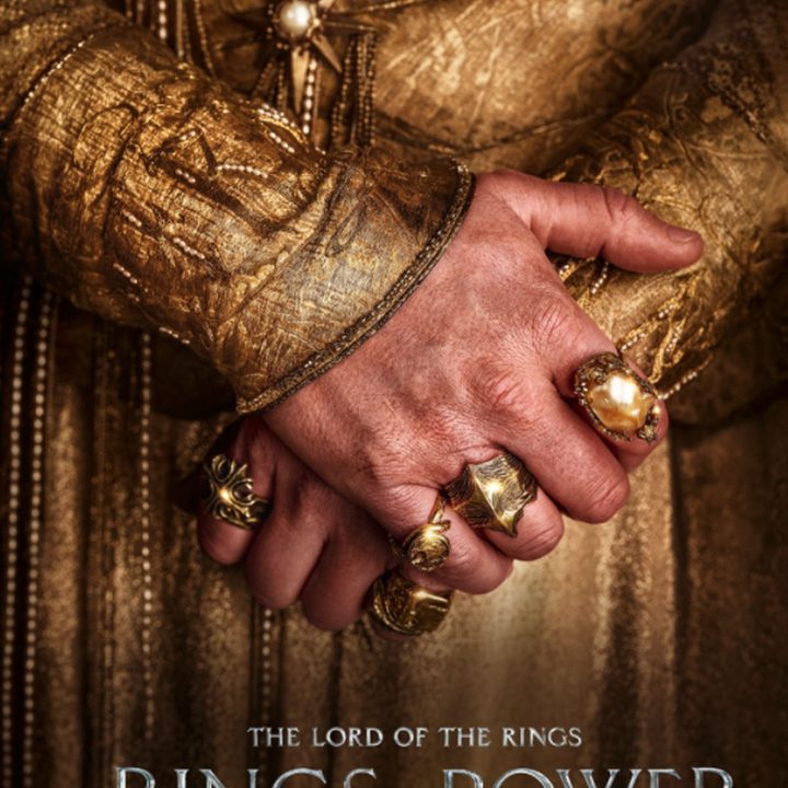 A hand sporting several rings in The Rings of Power.