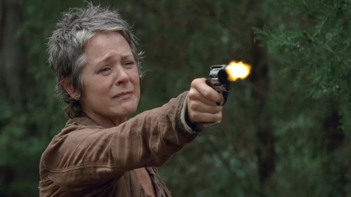 Carol pointing a gun at Lizzie and weeping in a scene from The Walking Dead.