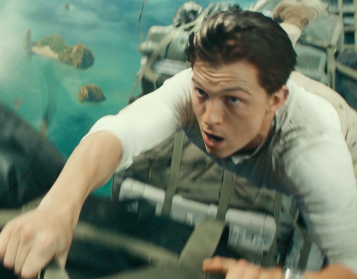 Tom Holland hangs off a cargo container in Uncharted.