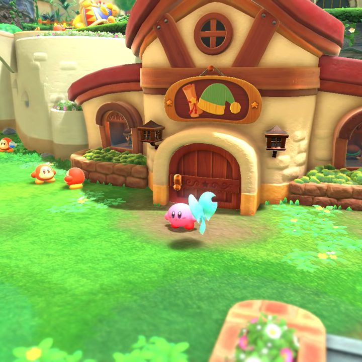 Kirby stands outside the weapon shop in Kirby and the Forgotten Land.