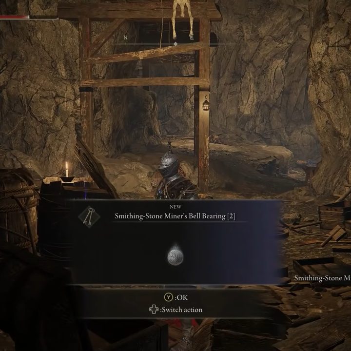 A knight collecting a bell bearing in a cave in Elden Ring.