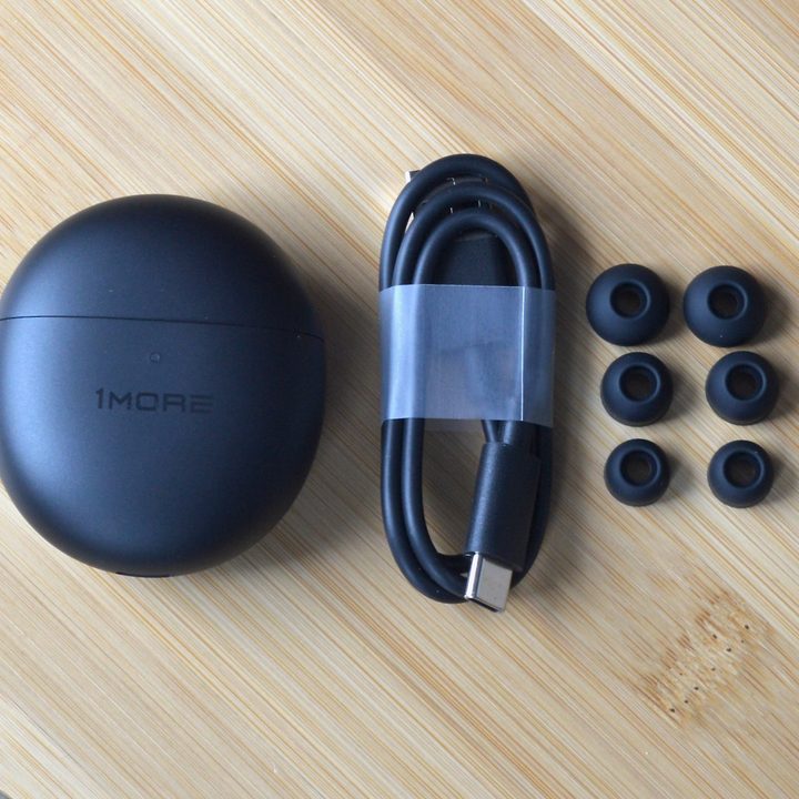 The 1More ComfoBuds Mini and accessories including a cable and ear cushions.
