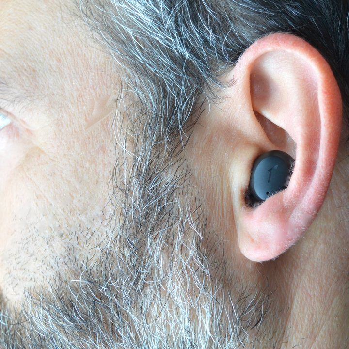A man wears the 1More ComfoBuds Mini earbuds.
