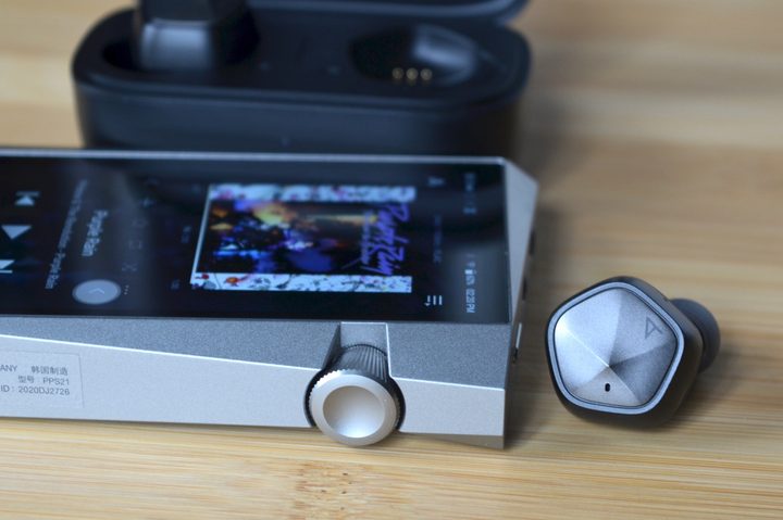 Astell&Kern AK UW100 earbuds seen next to the company's SR25 portable media player.
