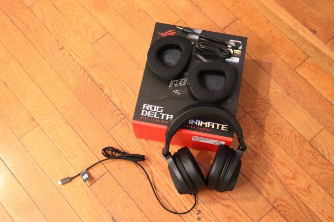 The Asus ROG Delta S Animate next to its packaging with additional accessories on a hardwood floor.