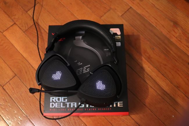The Asus ROG Delta S Animate headset sits on its packaging with heart-shaped effects on the outer display.