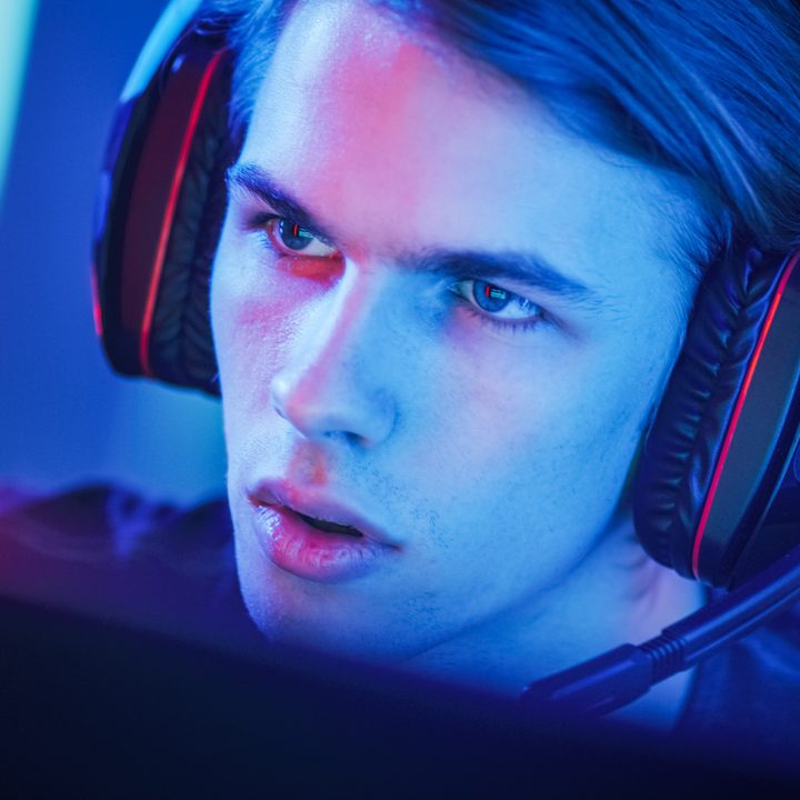 An intense-looking gamer with a gaming headset on.