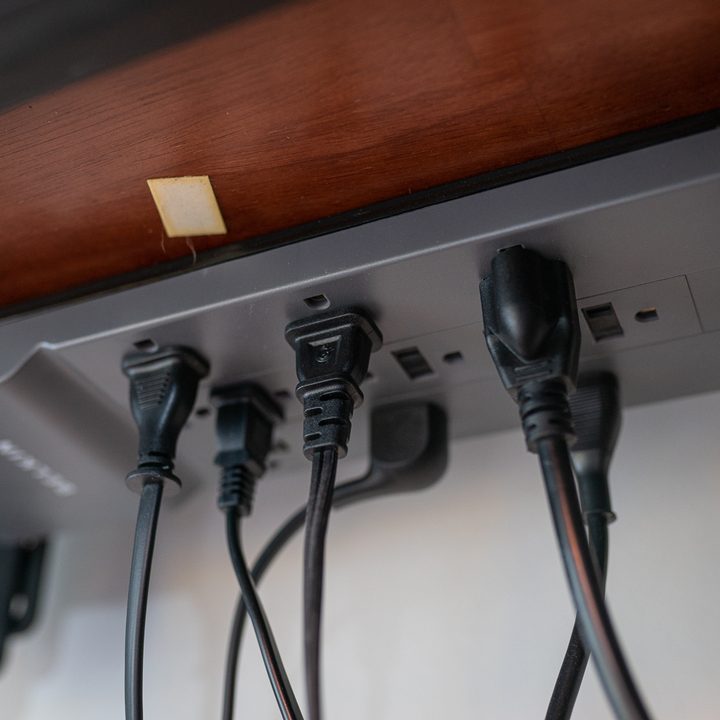 A power strip attached under a desk.