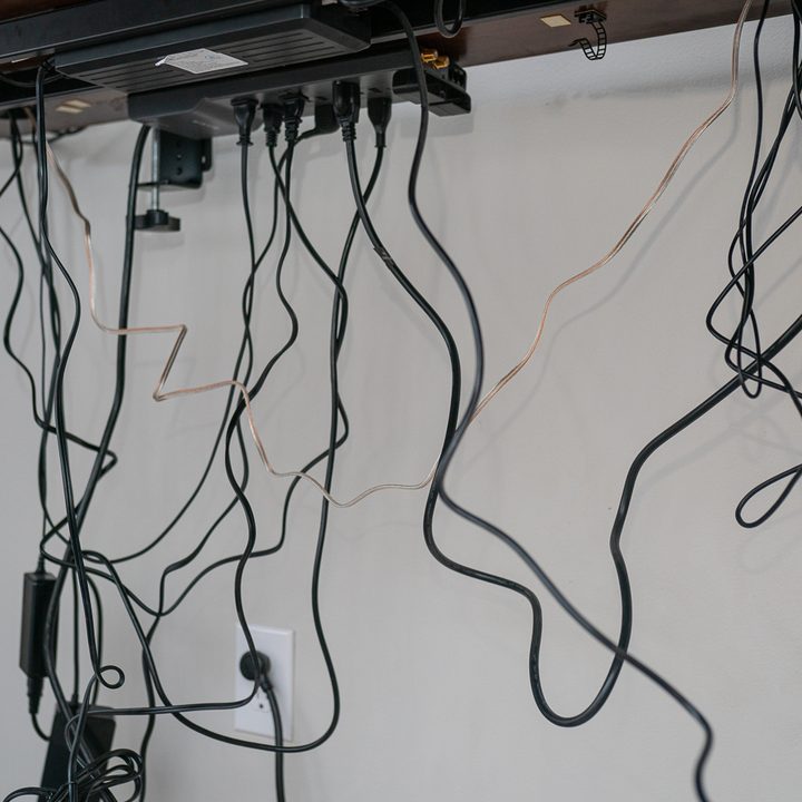 Cables hang under a desk.