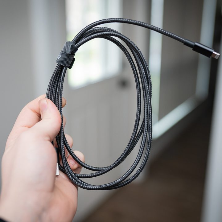 A hand holds a wrapped cable.