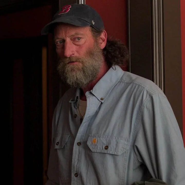 Troy Kotsur with a hat and beard in a scene from CODA.