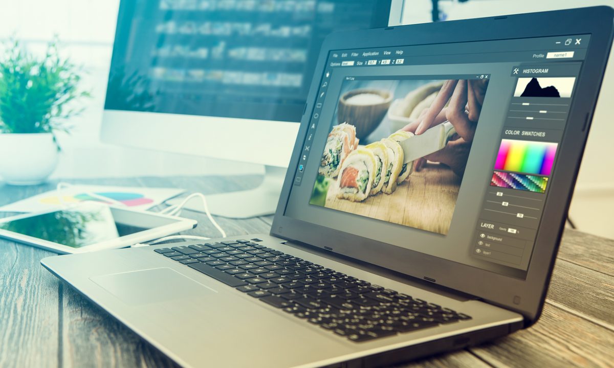 A laptop and PC/computer with an image editor program open.