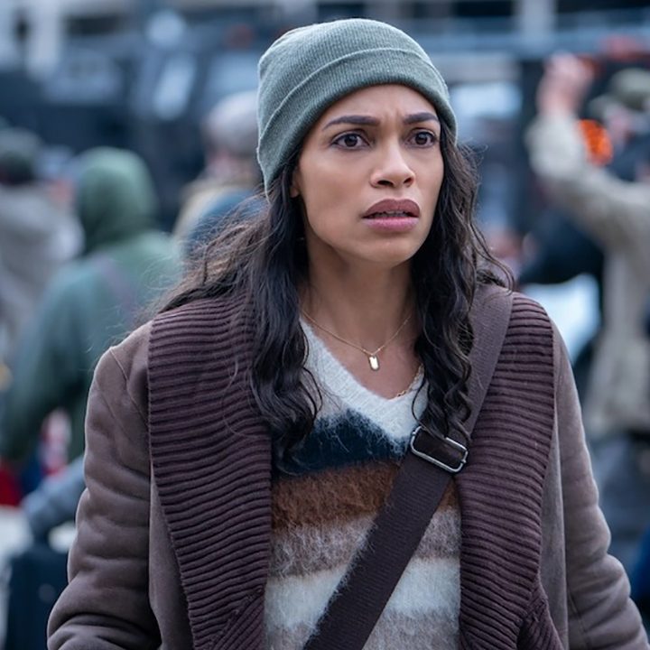 Rosario Dawson standing in a crowd looking scared in a scene from DMZ.