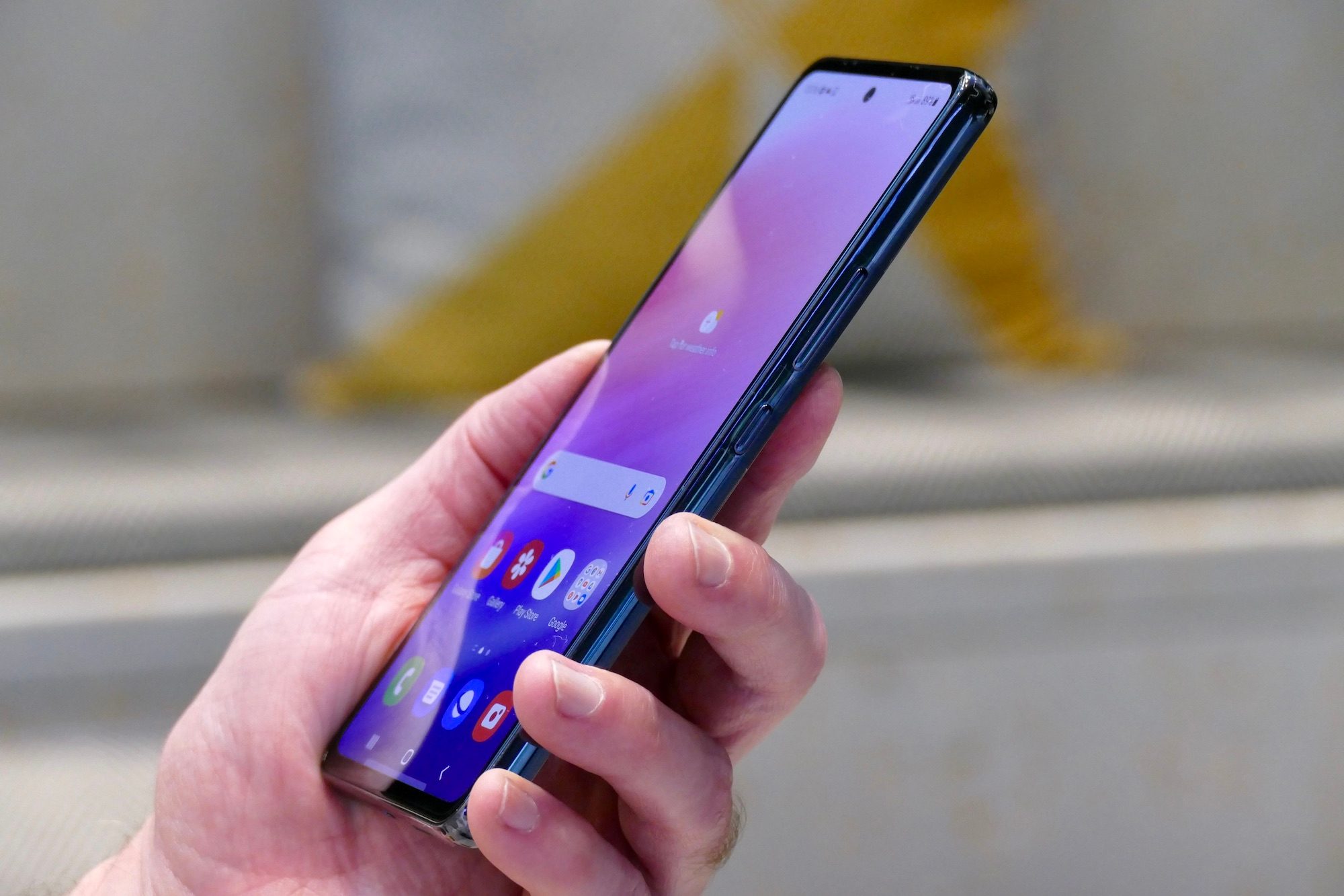 Samsung Galaxy A53 5G seen from the side and held in hand.