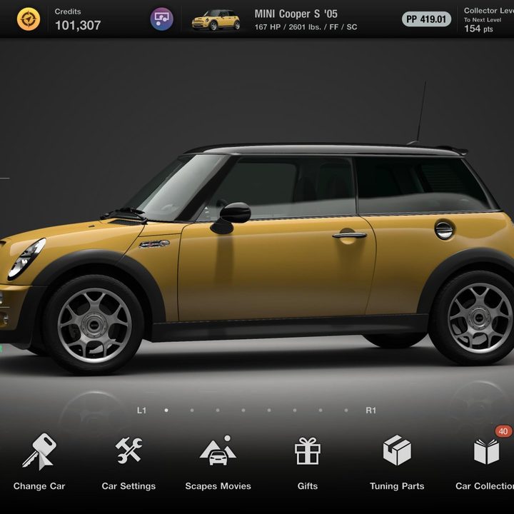 A yellow and black Mini Cooper S sits in the garage in Gran Turismo 7.