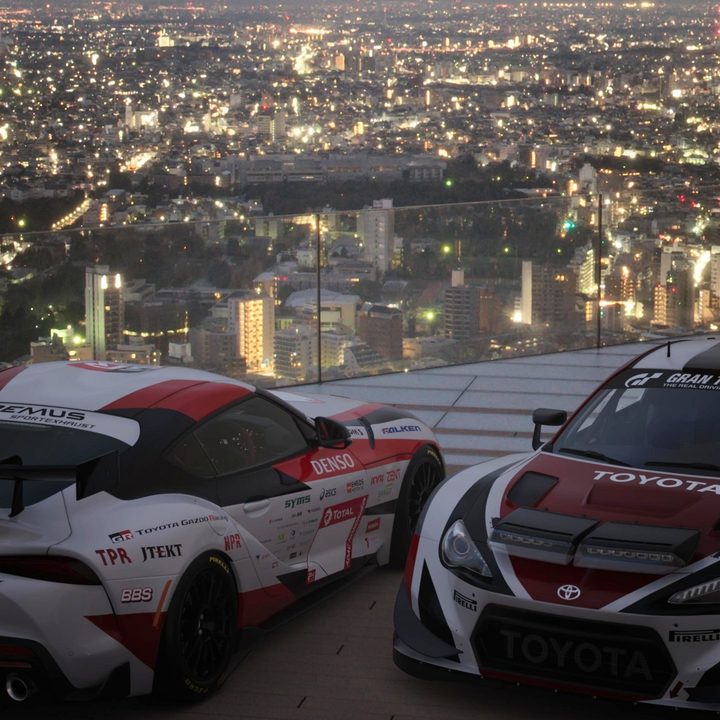 Two sports cars parked side by side on a rooftop in Japan in Gran Turismo 7.