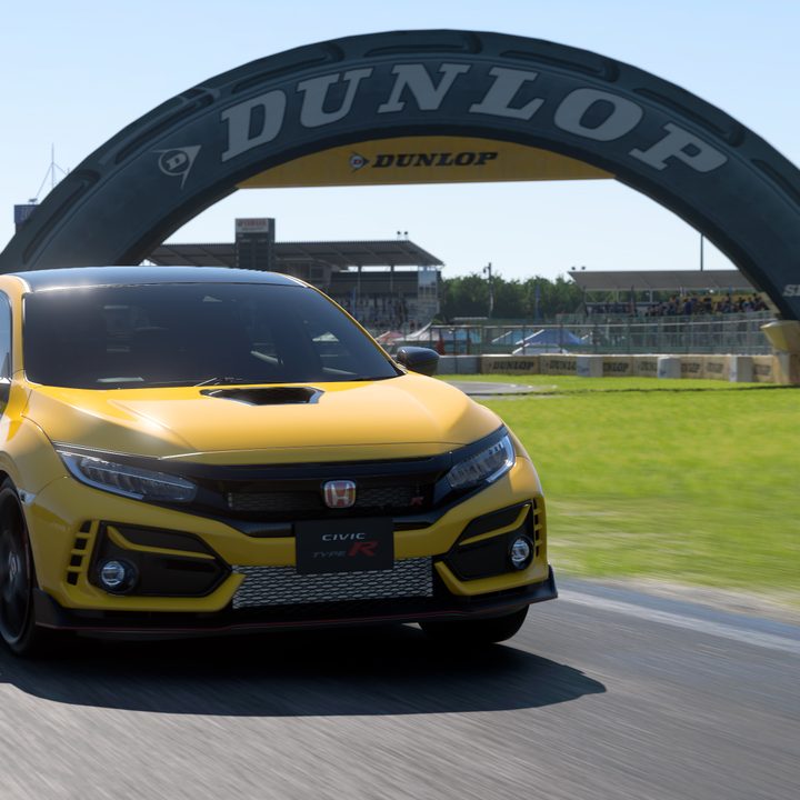 A Honda Civic Type R races on a Gran Turismo 7 track sponsored by Dunlop.