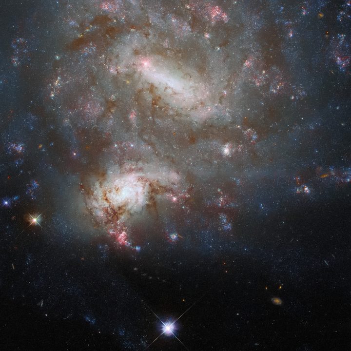 The twin galaxies NGC 4496A and NGC 4496B dominate the frame in this image from the NASA/ESA Hubble Space Telescope.