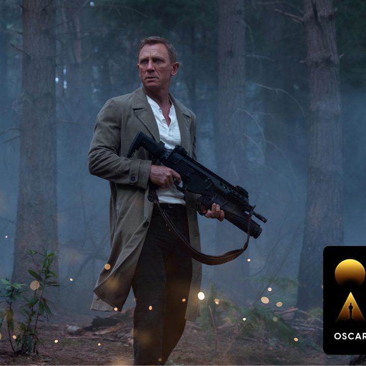 An "Oscars Week" badge on an image of Daniel Craig stands in a forest with a rifle in a scene from No Time To Die.