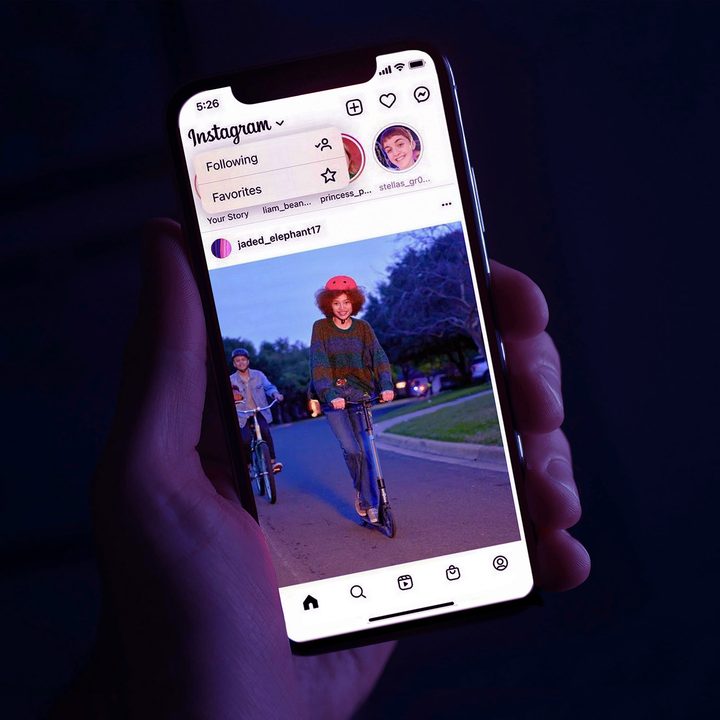 A person holds an iPhone in their hand while on the Instagram app.