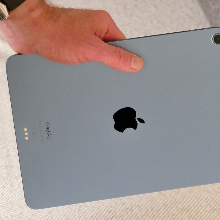 An iPad Air 5 seen from the back in a person's hand.