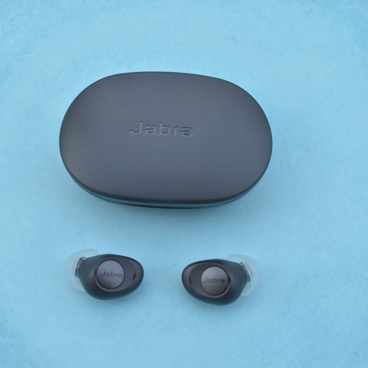 The Jabra Enhance Plus earbuds with case against a blue background.