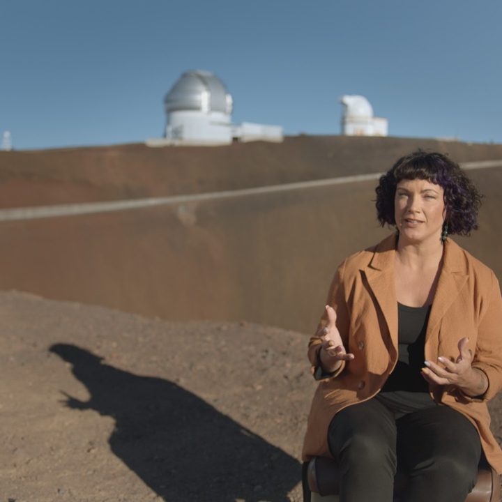 Astronomer Lucianne Walkowicz talks with deep space research stations seen in the background.