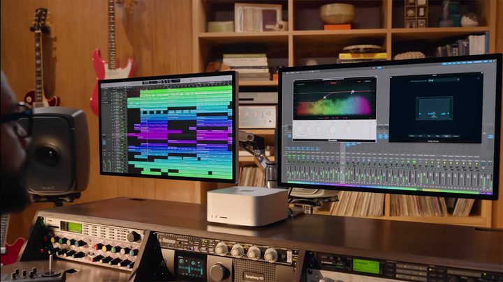 A person works at a station equipped with the all new Mac Studio and Studio Display.