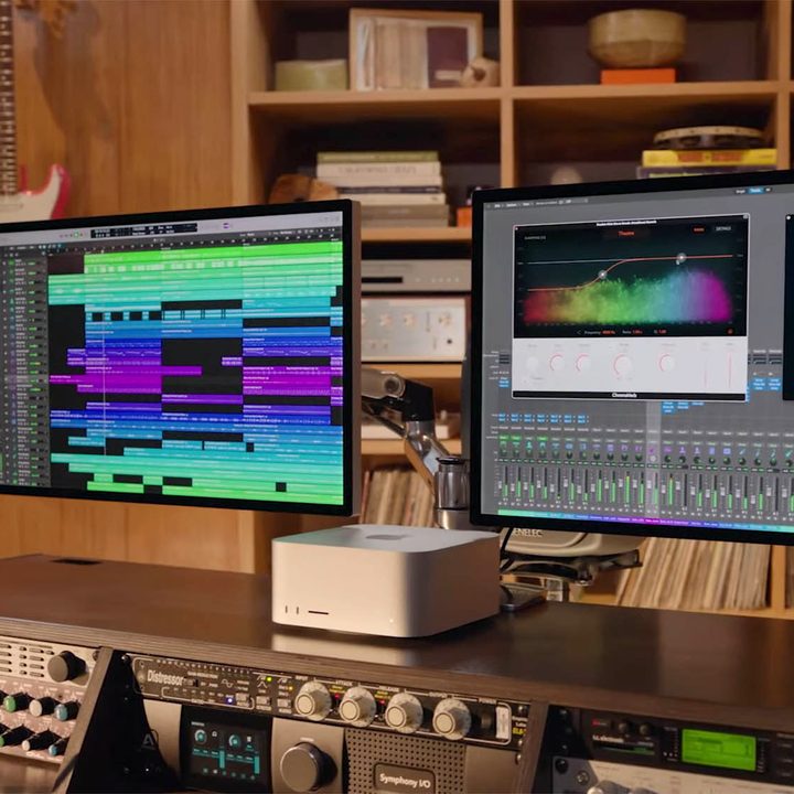 A person works at a station equipped with the all new Mac Studio and Studio Display.