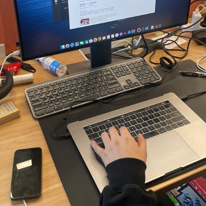 A person using the lower half of a MacBook Pro without the display.