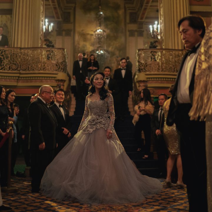Michelle Yeoh stands in the middle of a crowd in Everything Everywhere All At Once.