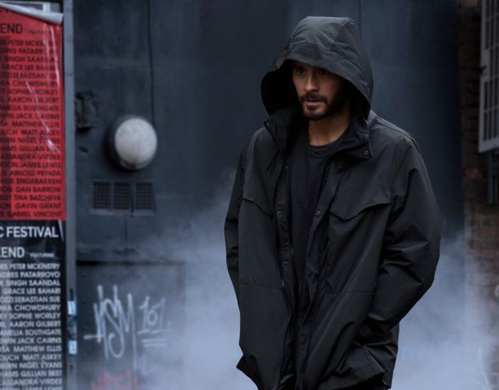 Jared Leto walks in a hooded raincoat in a scene from Morbius.