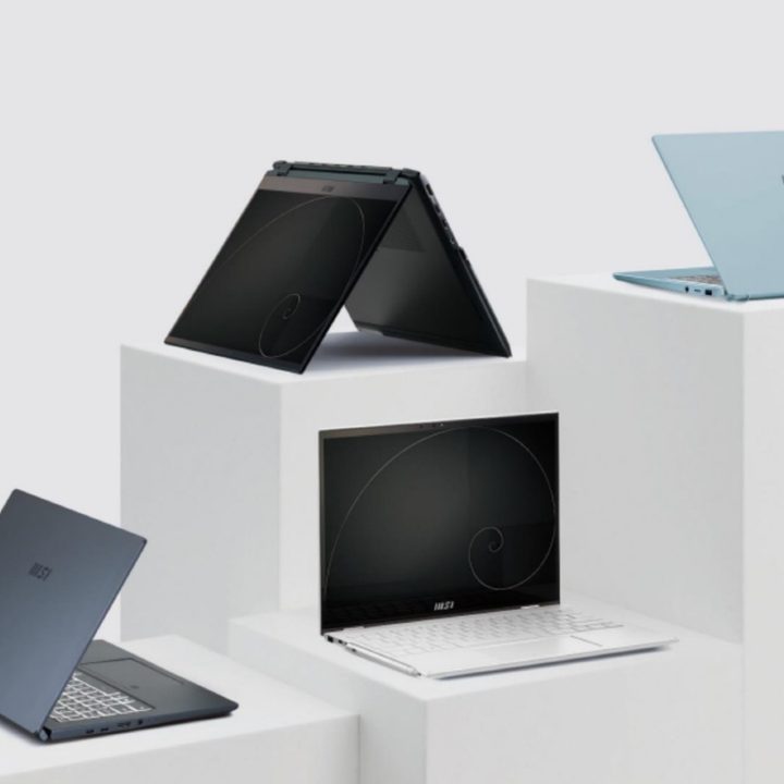 Four different MSI laptops on white stands in a white room.