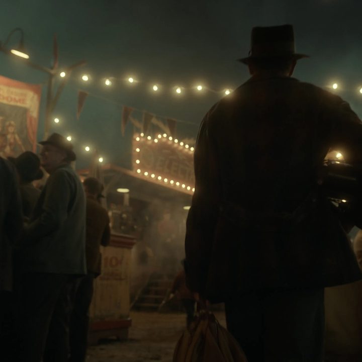 Stan arrives at a carnival at night in Nightmare Alley.