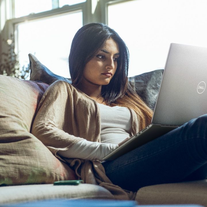 Woman on couch with XPS 17 on her lap.