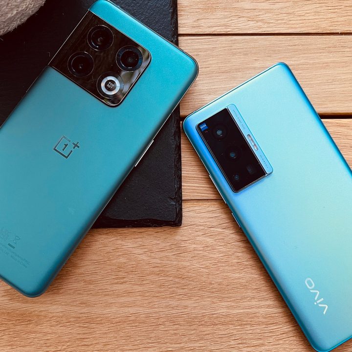 The OnePlus 10 Pro and Vivo X70 Pro seen from the back on a wood surface.