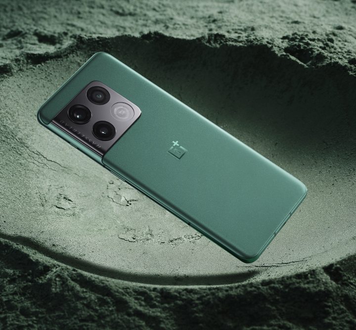 The OnePlus 10 Pro in Emerald Forest color on a sandy background.