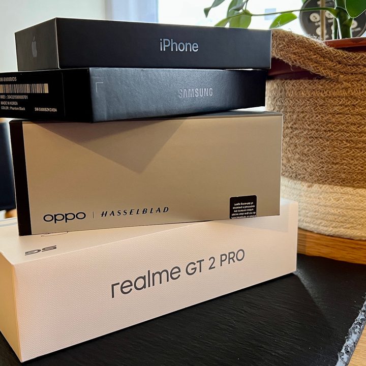 A pile of boxes for Apple, Samsung, Oppo, and Realme phones.