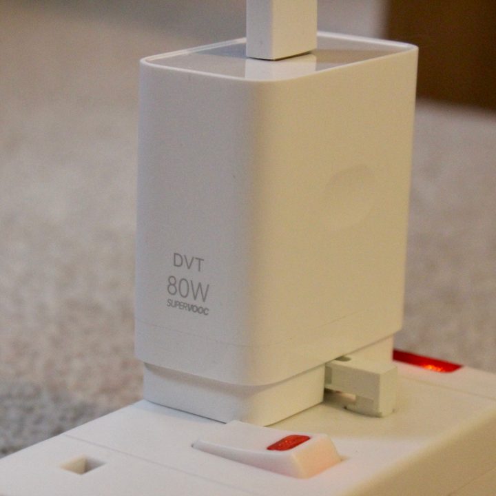 Oppo's SuperVOOC charging block plugged into a strip outlet.