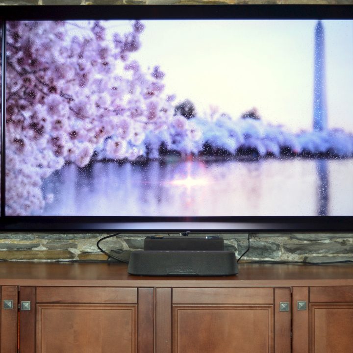 Polk MagniFi Mini AX seen in front of a 65-inch TV.